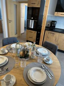 a wooden table with plates and wine glasses on it at Ferienwohnung in Kassel mit zwei Schlafzimmer in Kassel