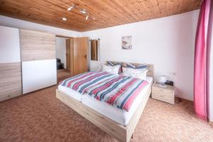 a bedroom with a large bed and a wooden ceiling at Gästehaus Jutta in Lindberg