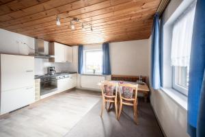 a kitchen with a table and chairs in a room at Gästehaus Jutta in Lindberg