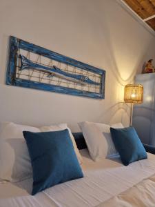 a white bed with blue pillows in a bedroom at Appartamento I TRE SANTI in Bisceglie +39 photos