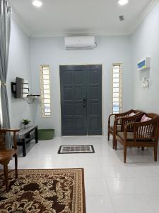 a living room with a black door and a rug at Che Puan Homestay Baling - 2 unit house with kids pool in Baling