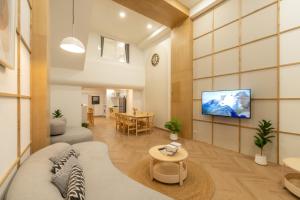 a living room with a couch and a tv on a wall at Tungyu Home Old Town - 1 min to walking street in Chiang Mai