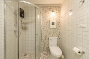 a bathroom with a toilet and a glass shower at Tungyu Home Old Town - 1 min to walking street in Chiang Mai +30 photos