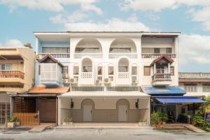 a white building with balconies on top of it at Tungyu Home Old Town - 1 min to walking street in Chiang Mai