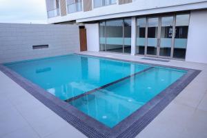 a swimming pool with blue water in a building at King's Kraft Shubh Hotel in Dwarka