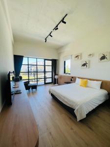 a bedroom with a bed and a large window at 杉灣小徑民宿 in Xiaoliuqiu