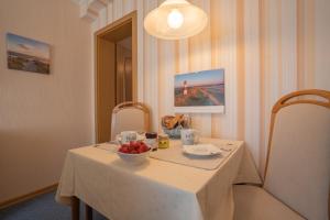 a white table with a bowl of fruit on it at Kim im Haus Wega in Westerland