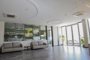 a large lobby with couches and windows in a building at King's Kraft Shubh Hotel in Dwarka