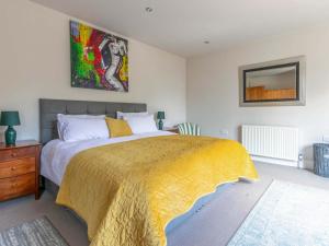 a bedroom with a large bed with a yellow blanket at Riverside in Stone