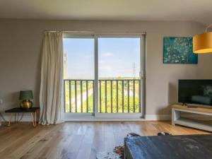 a living room with a large window and a television at Riverside in Stone