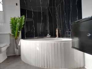 a bath tub in a bathroom with a plant at Vanilla Lee Guest House in Richards Bay +124 photos