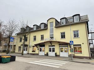a large yellow building on the corner of a street at Vievis Hotel Vievija in Vievis