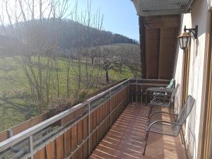 a balcony with two chairs and a table and a view at Haus am Limes in Pfedelbach