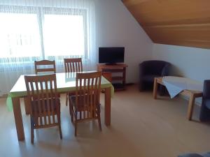 a room with a table and chairs and a television at Haus am Limes in Pfedelbach