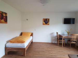 a bedroom with a bed and a table and a tv at Haus am Limes in Pfedelbach