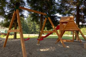 zwei Holzschaukeln in einem Park mit Bäumen in der Unterkunft Hostel LR in Nazarje