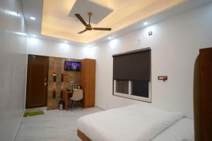 a bedroom with a bed and a flat screen tv at Hotel Shri Sai Palace Ayodhya in Faizābād