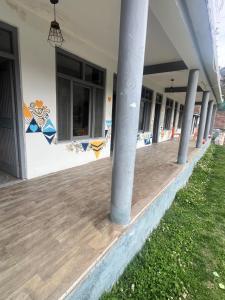 a building with a porch with columns on it at Green forest BnB and cafe in Manāli