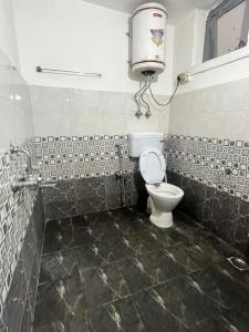 a bathroom with a toilet and a water tank at Green forest BnB and cafe in Manāli