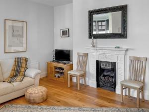 a living room with a couch and a fireplace at Flat 4 Sea Court in Swanage