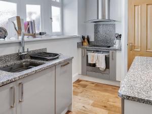 a white kitchen with a sink and a counter at Flat 4 Sea Court in Swanage