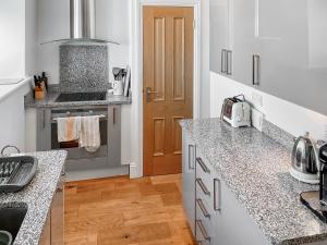 a kitchen with granite counter tops and a stove at Flat 4 Sea Court in Swanage +10 photos