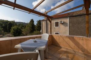 a patio with a table and chairs on a balcony at House Nešpula in Veli Lošinj