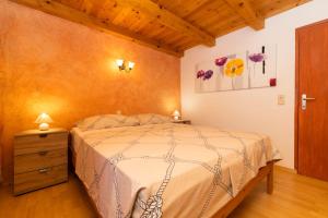 a bedroom with a bed and a wooden ceiling at House Nešpula in Veli Lošinj
