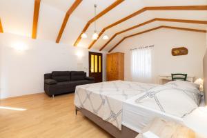 a bedroom with a large bed and a couch at House Nešpula in Veli Lošinj +22 photos