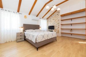 a bedroom with a bed and a television in it at House Nešpula in Veli Lošinj