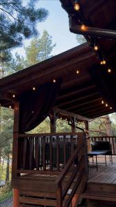 a pavilion with a bench on a wooden deck at Nice House in Maidan Village +5 photos