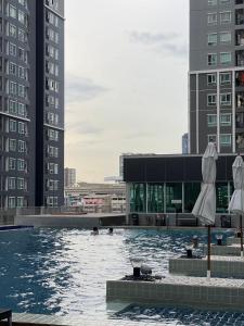 a pool with two umbrellas in the middle of a building at Regenthome 28A in Bang Su