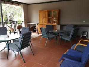 a restaurant with tables and chairs and a balcony at Loerie Guesthouse in Hoedspruit