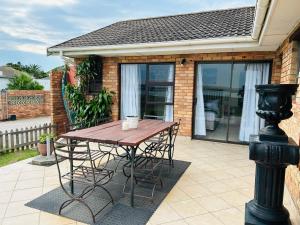 a wooden table in front of a house at River Front Guest House in Gqeberha