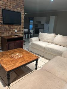 a living room with a couch and a coffee table at River Front Guest House in Gqeberha