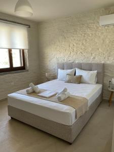 a bedroom with a large bed with towels on it at Villa Cavo d' Oro in Korissia