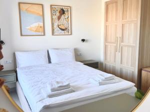 a bedroom with a white bed with towels on it at Covea by the Sea Boho Seaside Apartment, 400 m from the Beach in Perea