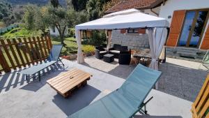 a patio with a table and chairs and an umbrella at Tra il Mare e i Monti in Sanremo