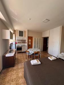 a room with two beds and a table and a kitchen at MONOLOCALI DA VINCI in Falconara Marittima