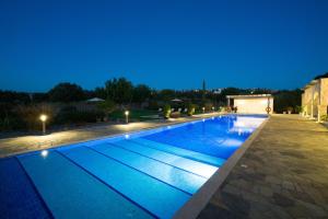 uma piscina iluminada à noite em 5 bedroom Villa Rio with large private pool and hot tub, Aphrodite Hills Resort em Kouklia