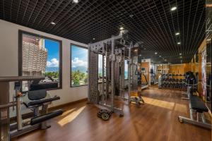 a gym with treadmills and machines in a room at Holiday Beach Hotel Danang in Danang