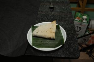 a piece of food on a plate on a table at Hotel Ashoka Kokan Ganpatipule in Ganpatipule