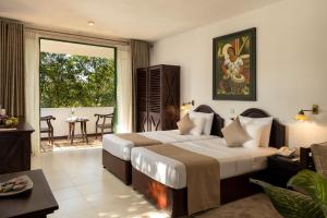 a hotel room with two beds and a balcony at Tree of Life Nature Resort in Kandy