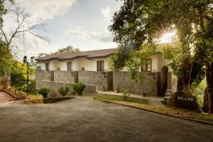a house with a stone wall and a driveway at Tree of Life Nature Resort in Kandy +88 photos