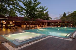 a swimming pool with tables and chairs in a resort at Tree of Life Nature Resort in Kandy