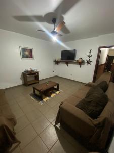 a living room with a couch and a ceiling fan at Casa com piscina Perto Da Praia Em FIGUEIRA in Arraial do Cabo
