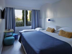 ein Hotelzimmer mit zwei Betten und einem Fenster in der Unterkunft Amadria Park Kids Hotel Andrija in Šibenik + 30 Fotos