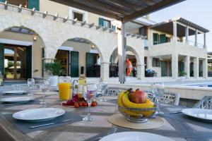 a table with a bowl of fruit and glasses of orange juice at 5 bedroom Villa Rio with large private pool and hot tub, Aphrodite Hills Resort in Kouklia