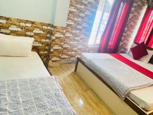 a bedroom with two beds and a brick wall at Global hotel in Pānigata