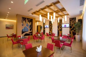 a dining room with tables and red chairs at Ararat Resort Tsaghkadzor in Tsaghkadzor